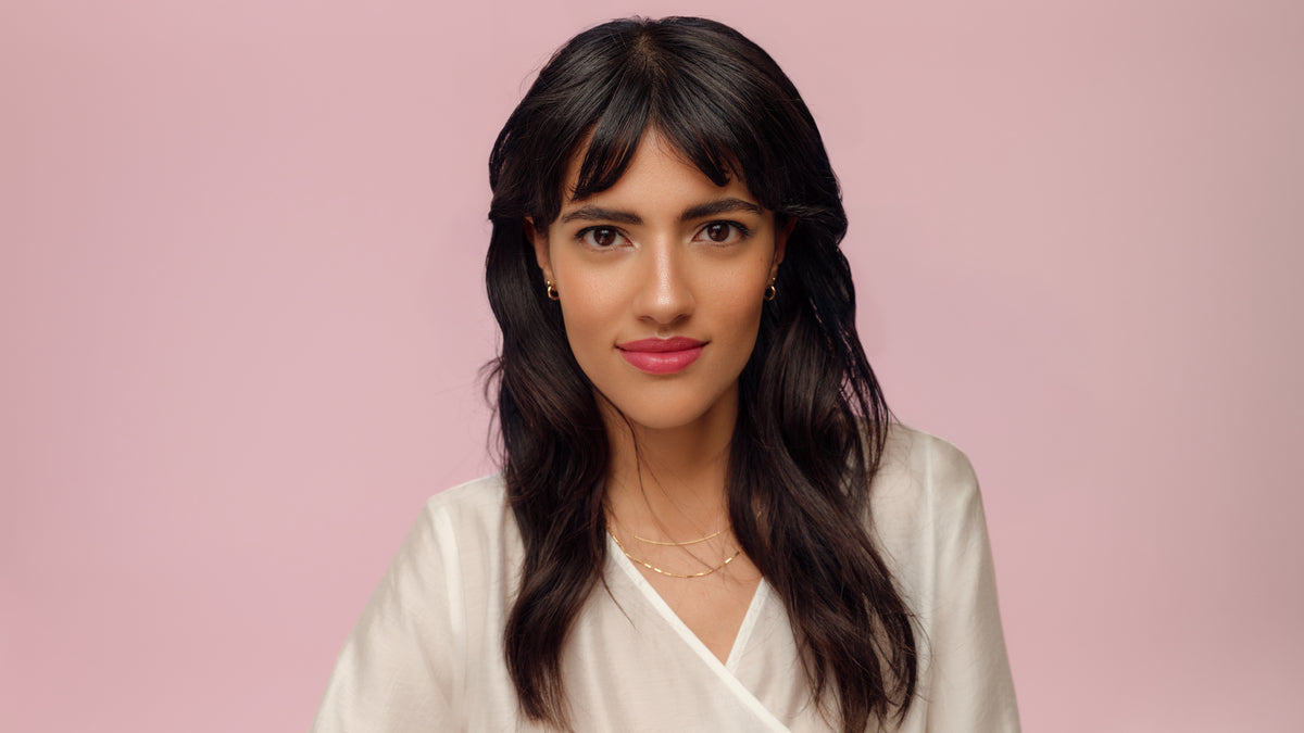 Junge Frau mit dunkelbraunen Haaren, braunen Augen und einem eleganten Make-up Look