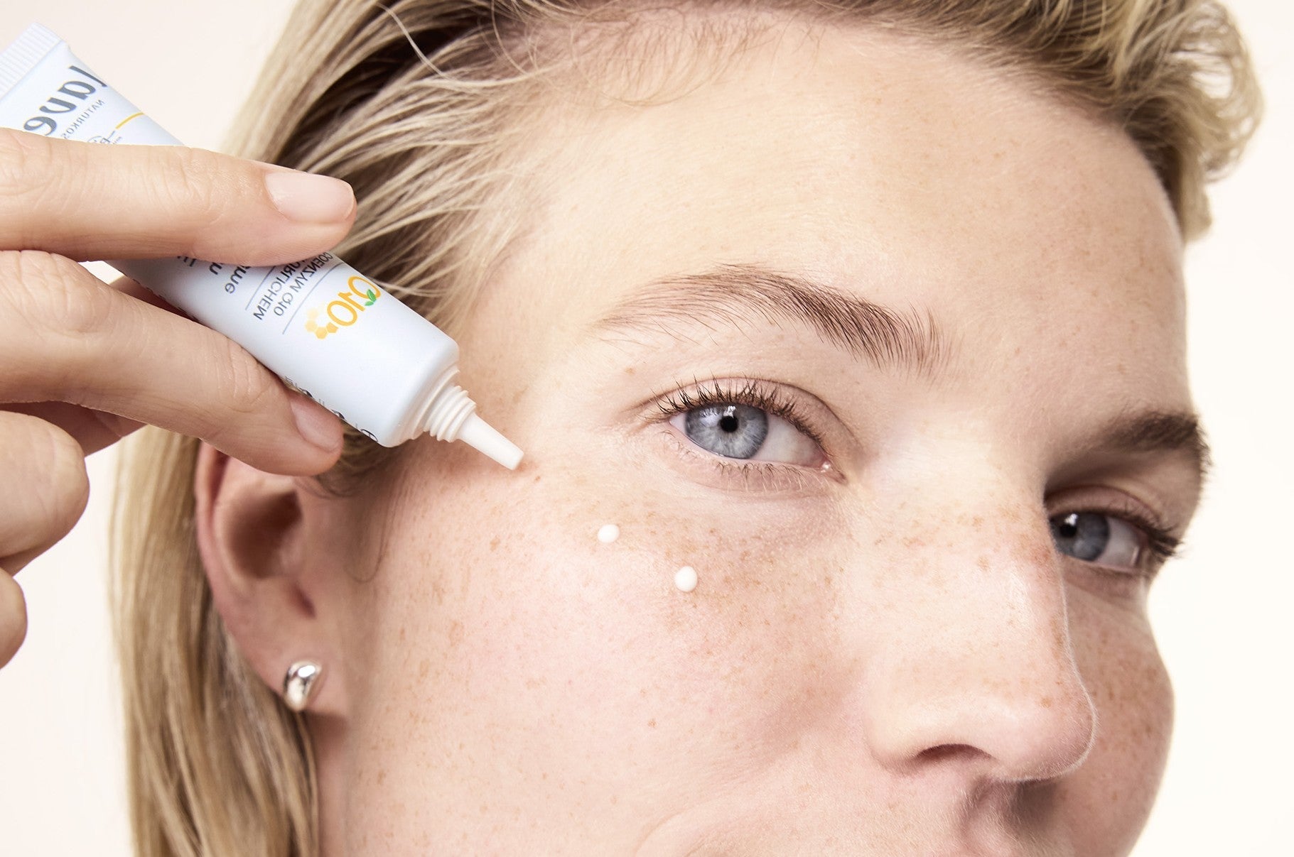 Frau trägt Augencreme auf das Gesicht puntweise auf
