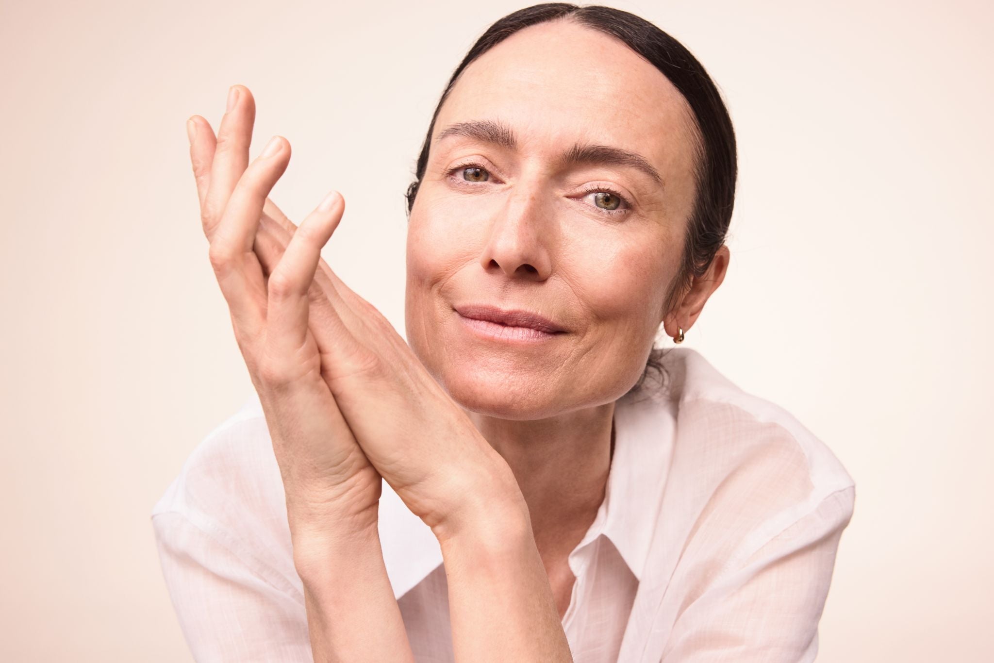 Frau mit den gefalteten Händen neben Gesicht