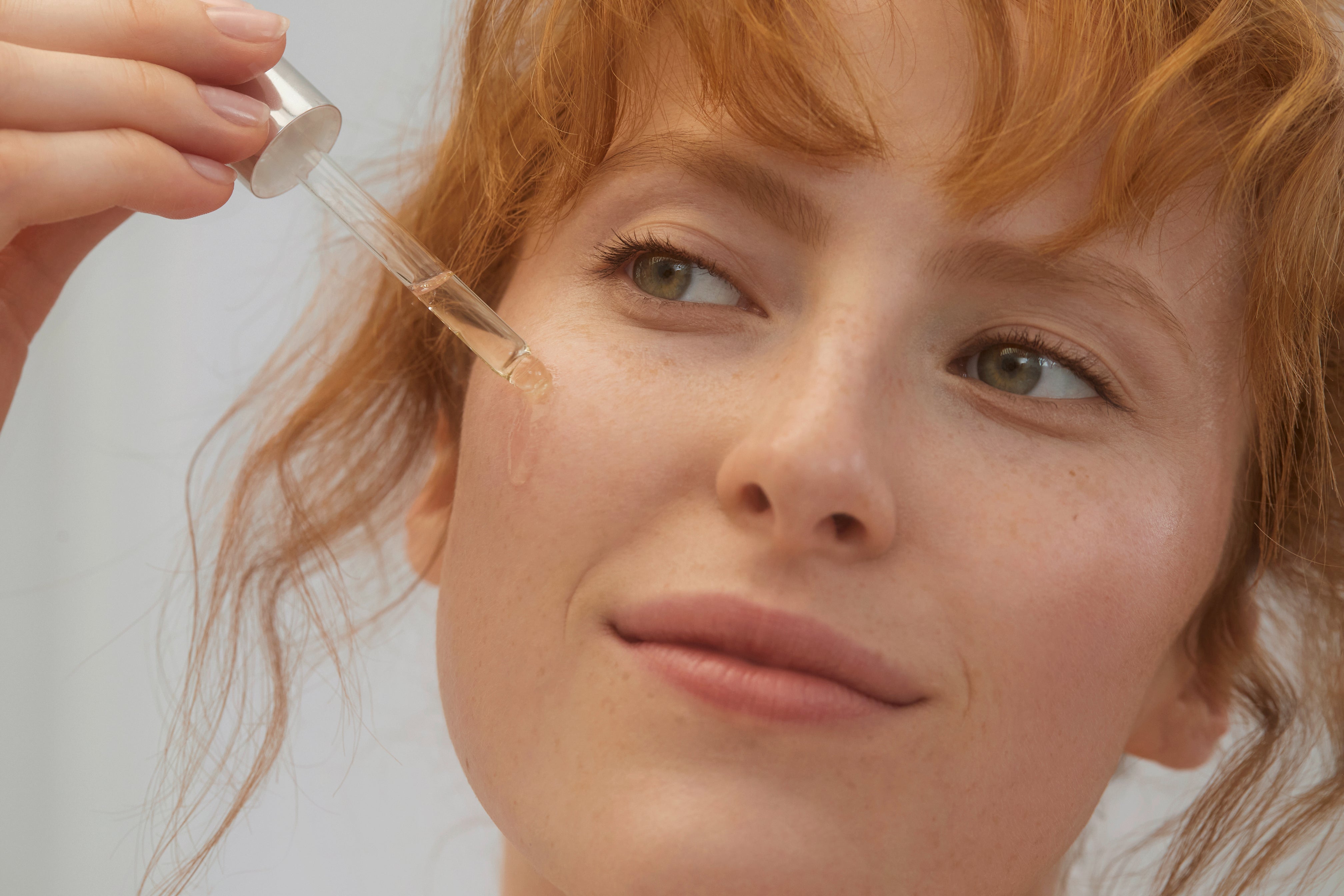 Frau trägt lavera Re-Energizing Produkt auf das Gesicht mit der Pipette auf