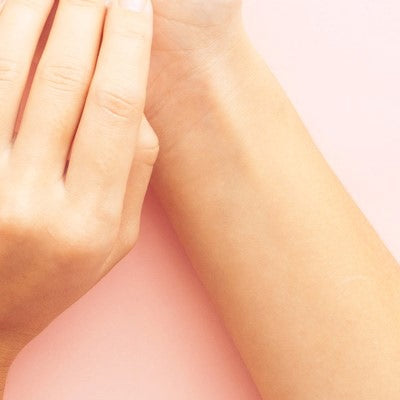 Handgelenk und Hand vor rosafarbenem Hintergrund