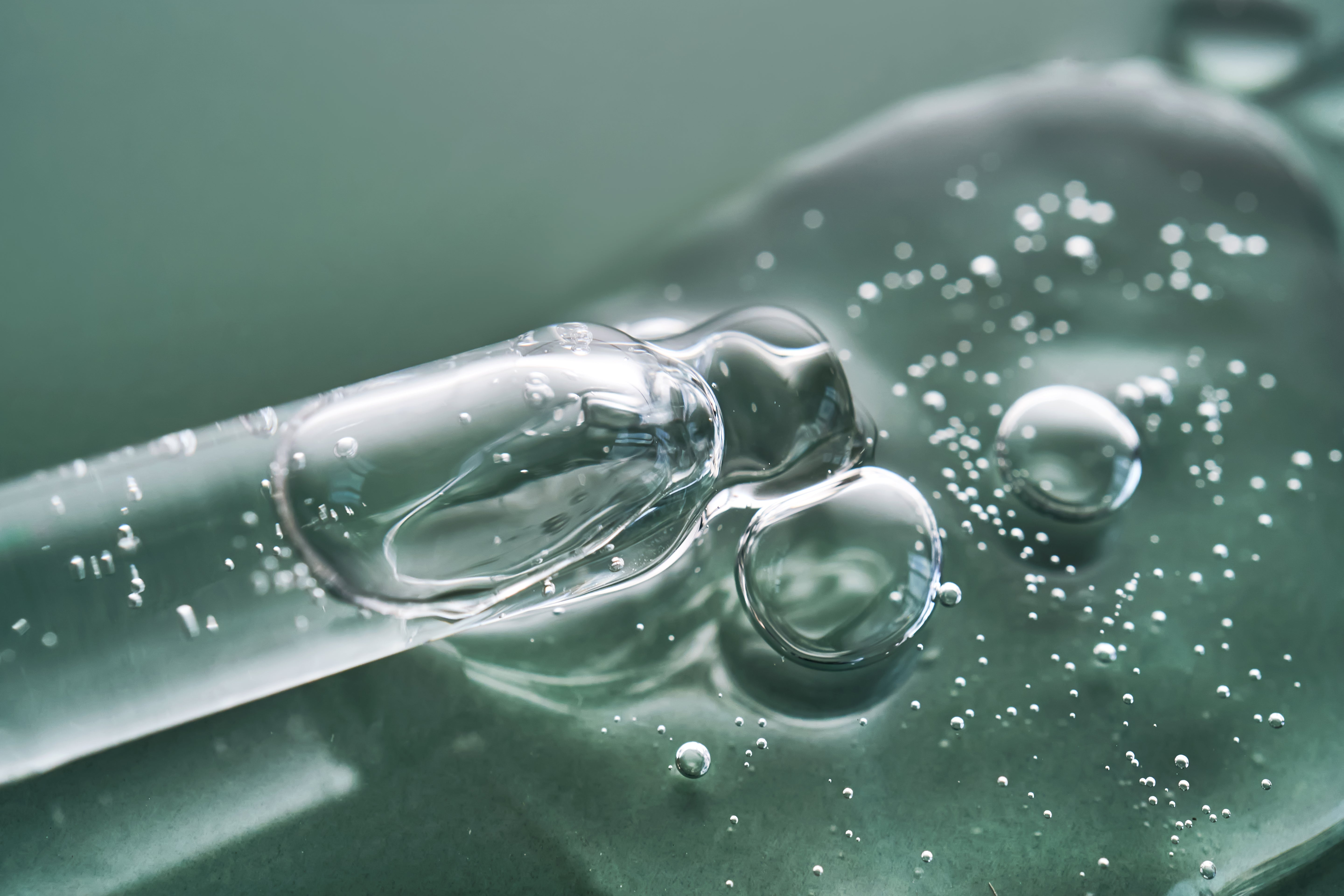 Pipette mit durchsichtigen Serum vor grünem Hintergrund