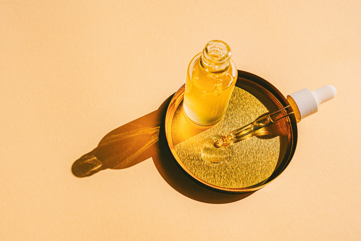 Pipette und Glasflasche mit gelbem Öl