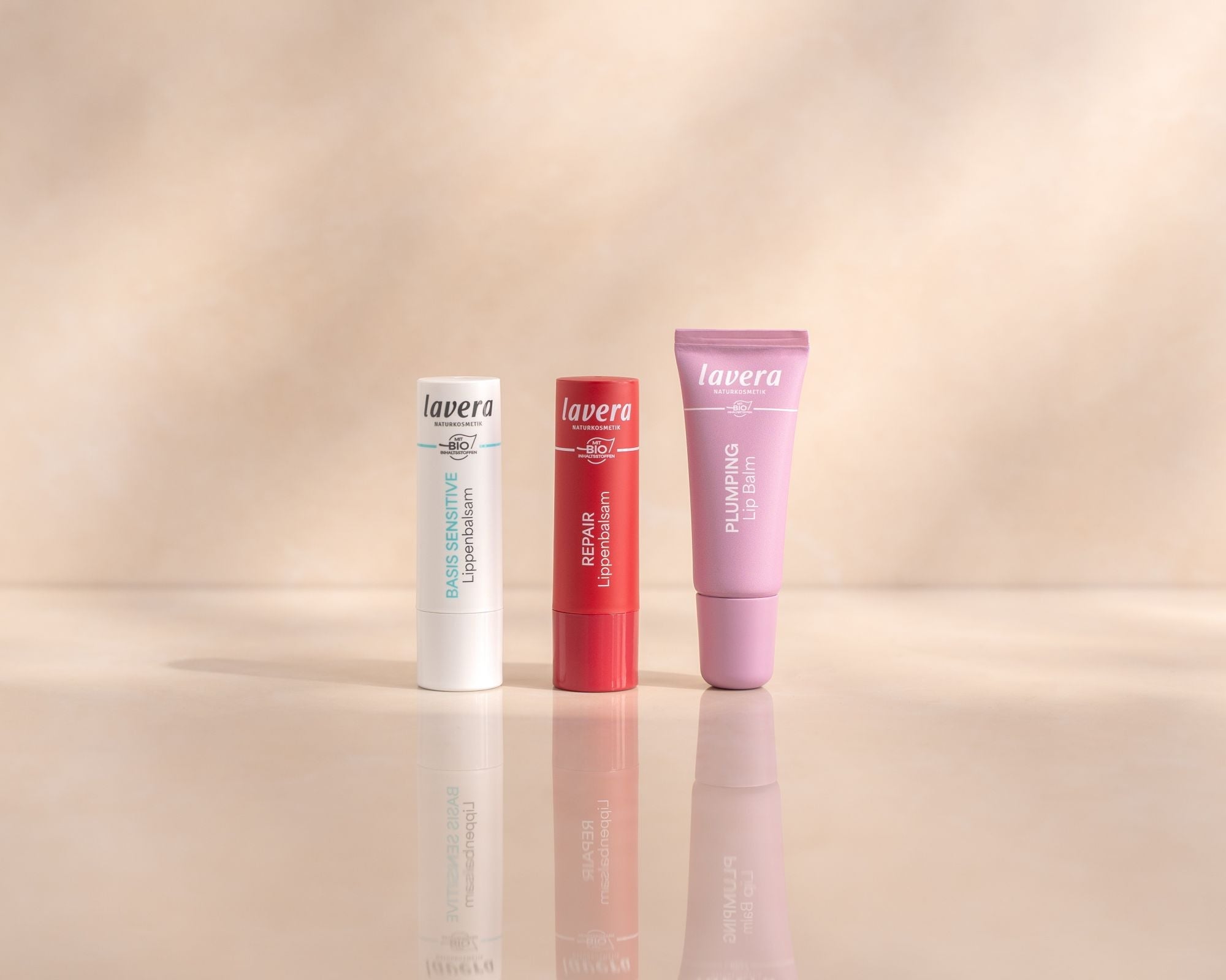 Drei Lavera Lippenpflegeprodukte nebeneinander auf dem hellen Hintergrund: Basis Sensitive, Repair und Plumping Lip Balm.