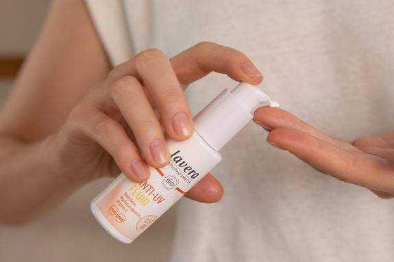 Hand dosiert lavera LSF-Fluid auf Finger