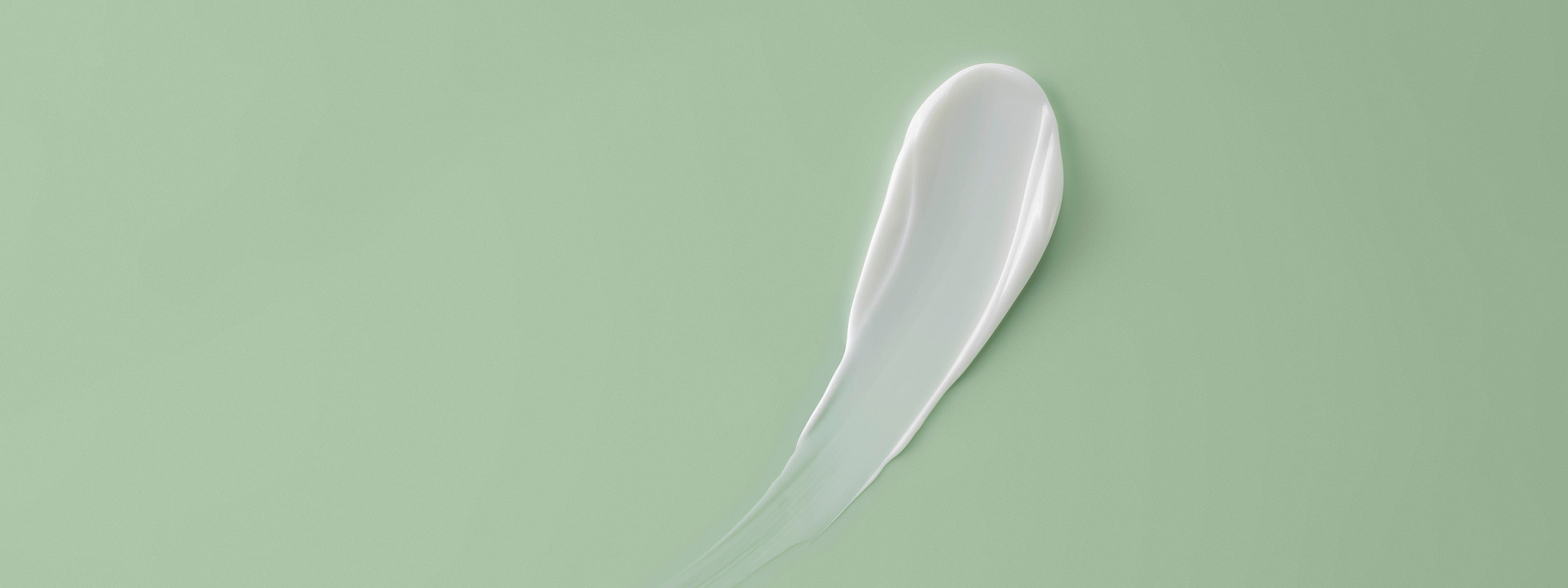 Creme Textur auf grünem Hintergrund