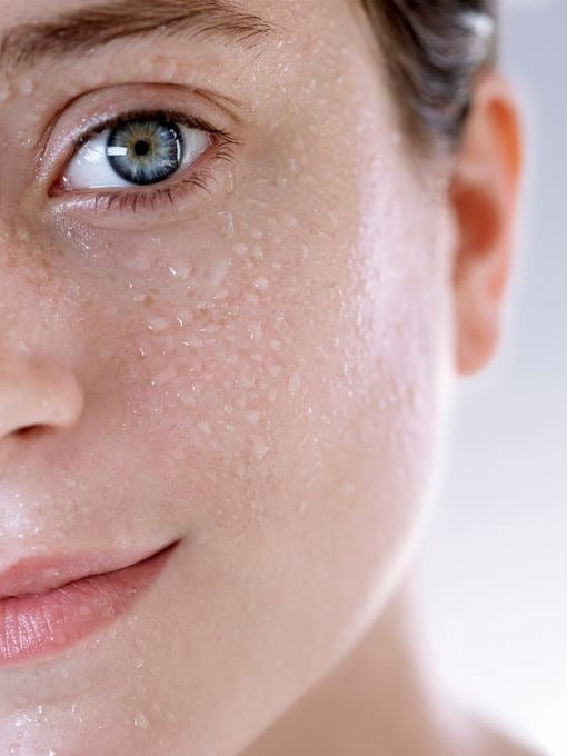 Nahaufnahme: Gesicht mit Wassertropfen auf der Haut, frischer Glow